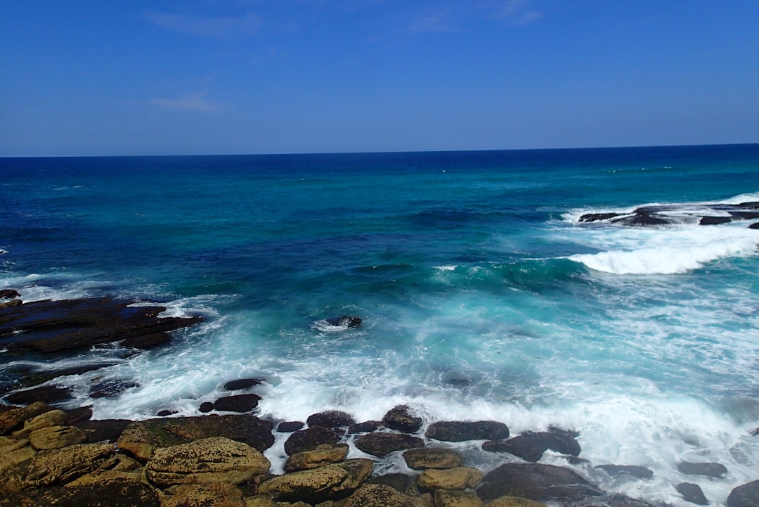 Turquoise water foaming over dark rock platforms on the Sydney coast